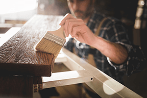 Personne appliquant de l'huile sur une planche en bois